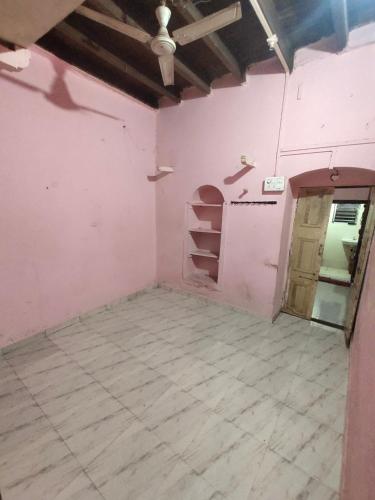 une pièce vide avec des murs roses et une porte dans l'établissement Mohak Yatri Nivas मोहक यात्री निवास, à Kolhapur