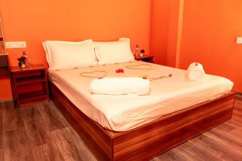 a bedroom with a bed with white sheets and towels at SEASUNBEACH Maafushi in Maafushi