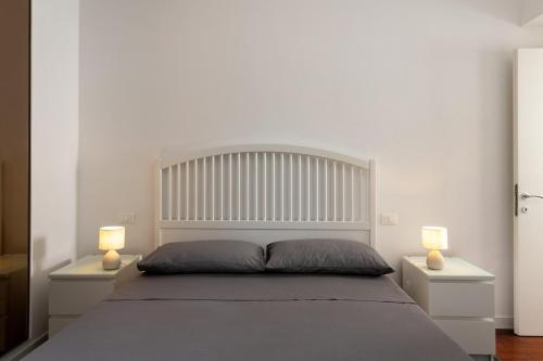 una camera da letto con un grande letto bianco con due lampade di The Garden's Home-Casa Rimini Marina centro a Rimini