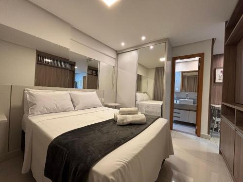 um quarto com uma cama grande e um banheiro em LUX26 - Flat Próx Órion Cozinha Completa com Varanda em Goiânia