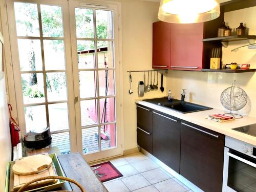une cuisine avec un évier et une grande fenêtre dans l'établissement Duplex 4 Pers - 80 m2 - Abatilles - Grande Terrasse - Parking, à Arcachon