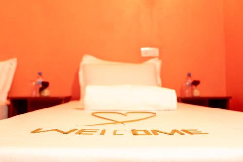 a bed with a welcome sign on the top of it at SEASUNBEACH Maafushi in Maafushi