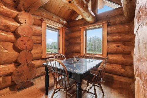 a dining room with a table and chairs in a log cabin at Log Retreat at Fish Creek by Simple Life Rentals in Fish Creek