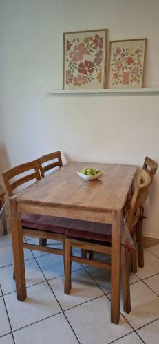 a wooden table and chairs with a bowl of greens on it at Ferienwohnung alte Backstube in Lage