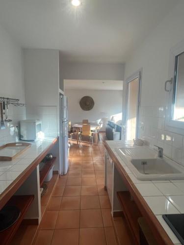 une cuisine avec des comptoirs blancs et une salle à manger dans l'établissement Villa Cala Rossa 3 chambres, à Lecci