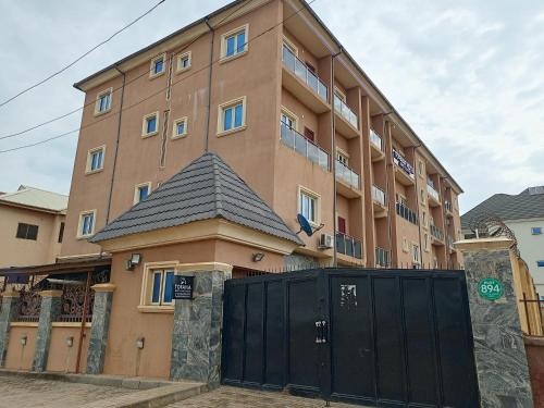 a large building with a black gate in front of it at Tofana Hotel and Suites Mabushi in Abuja