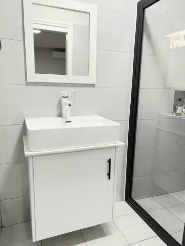 a bathroom with a white sink and a mirror at Residence Sunset 3 bedrooms appartment in Midlands Station