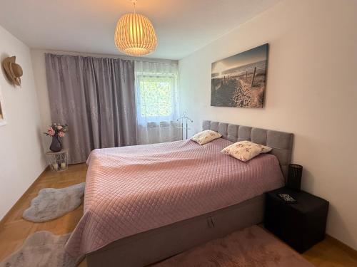 a bedroom with a bed and a chandelier at FerienNest Traunreut in Traunreut