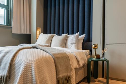 a bedroom with a large bed with a blue headboard at Unity Hammarby Sjöstad - A Studio Hotel in Stockholm