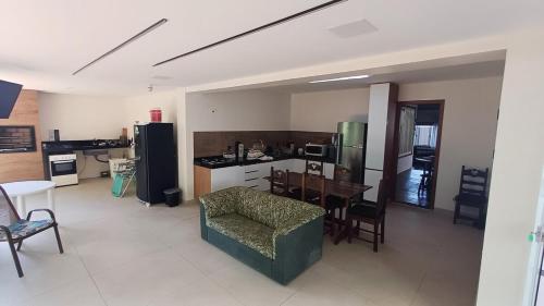 a kitchen with a couch and a table in a room at Casa de praia em Itaúna, Saquarema, Pertinho do mar 150 m da areia com 3 quartos e ar condicionado in Saquarema