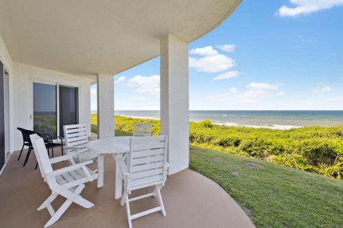 a porch with a table and chairs and the ocean at HP 16E Beach Treat by 30A Escapes in Rosemary Beach