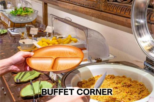a person holding a pot of food in a buffet at BaliAn Resort Chiba-Chuo in Chiba