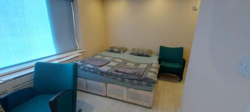 a small room with a bed and two chairs at Romford Lodge in Romford