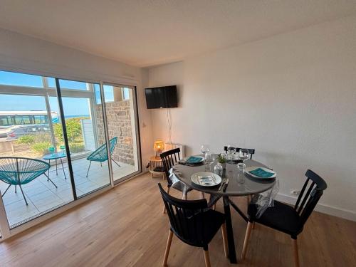 une salle à manger avec une table et des chaises et un balcon dans l'établissement Le Nid de Keragan, à Ploemeur