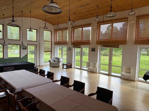 a large room with a table and chairs and windows at Oaza Spokoju Pod Warszawą in Marianka