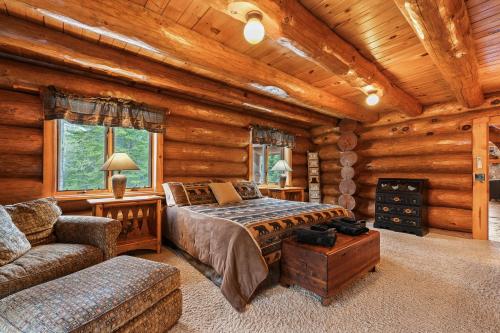 a bedroom in a log cabin with a bed and a couch at Log Retreat at Fish Creek by Simple Life Rentals in Fish Creek