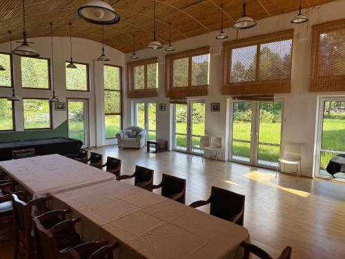 a large room with tables and chairs and windows at Oaza Spokoju Pod Warszawą in Marianka