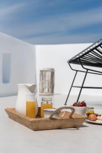 a tray of food with a plate of food and orange juice at Seven Suites in Glinado Naxos