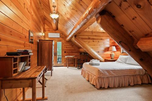 a bedroom in a log cabin with a bed and a desk at Log Retreat at Fish Creek by Simple Life Rentals in Fish Creek
