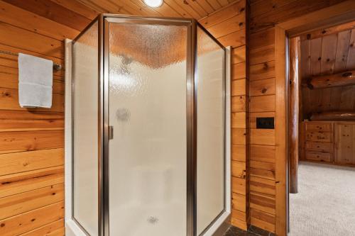 a walk in shower in a room with wooden walls at Log Retreat at Fish Creek by Simple Life Rentals in Fish Creek