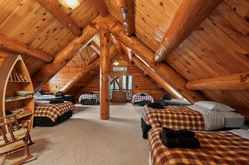 a attic room with three beds and wooden ceilings at Log Retreat at Fish Creek by Simple Life Rentals in Fish Creek