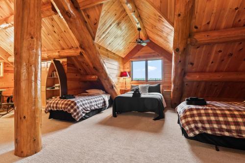 a bedroom with two beds in a log cabin at Log Retreat at Fish Creek by Simple Life Rentals in Fish Creek