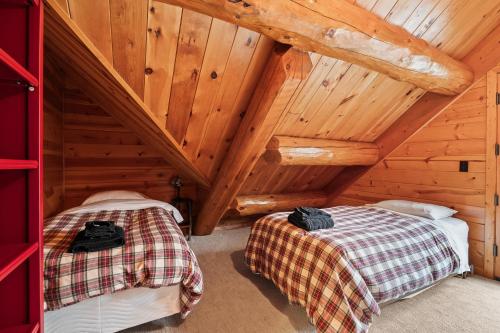 a bedroom with two beds in a wooden cabin at Log Retreat at Fish Creek by Simple Life Rentals in Fish Creek