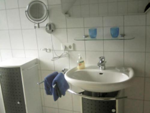 y baño con lavabo y espejo. en Ferienwohnung Strudthoff, en Ganderkesee