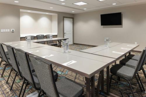 a conference room with tables and chairs and a screen at Residence Inn by Marriott Albany Clifton Park in Clifton Park