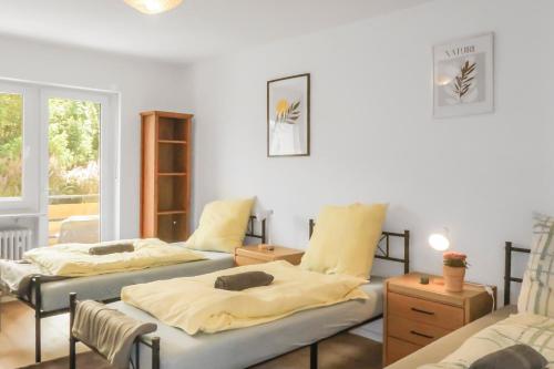 a room with two beds with yellow sheets at Brody Apartments I Cozy Stay zwischen Friedberg und Bad Nauheim in Oberwöllstadt