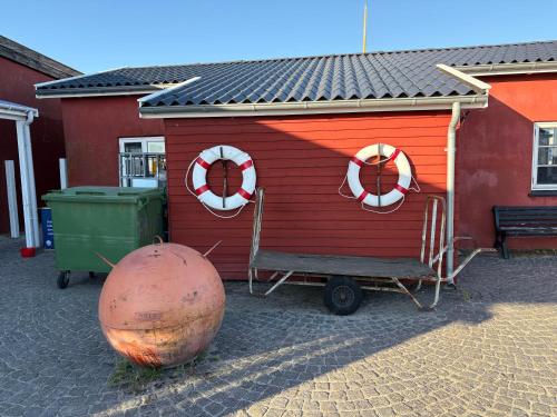 a red building with two life preservers and two life rings at Charmerende hus i idylliske Lynæs in Hundested