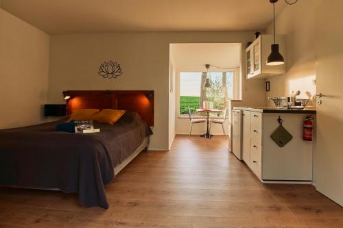 una camera da letto con un letto e una cucina con un tavolo di Ferieidyl a Kettinge