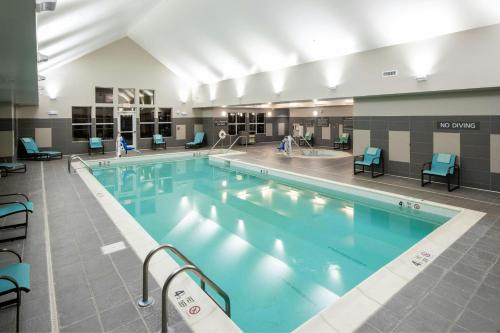 a large swimming pool with blue chairs around it at Residence Inn by Marriott Albany Clifton Park in Clifton Park