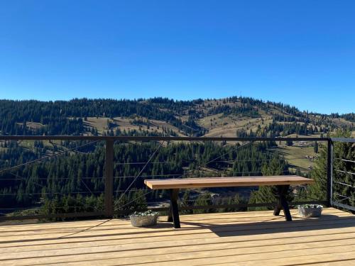 a bench sitting on a deck with a view of a mountain at Fanar Chalet in Glodu