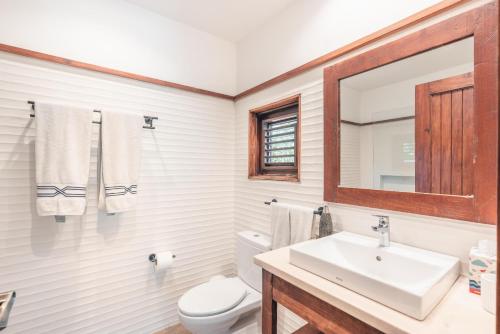a bathroom with a sink and a toilet and a mirror at Fun in the sun classic villa at Los Lagos in Casa de Campo in Las Minas