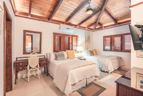 a bedroom with two beds and a desk at Fun in the sun classic villa at Los Lagos in Casa de Campo in Las Minas