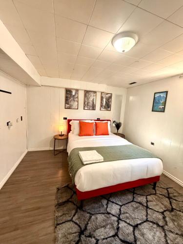a bedroom with a large bed with orange pillows at The house Londonderry mall in Edmonton