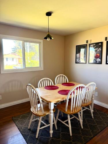 a dining room with a wooden table and chairs at The house Londonderry mall in Edmonton
