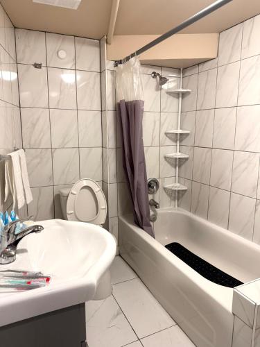 a white bathroom with a tub and a sink at The house Londonderry mall in Edmonton