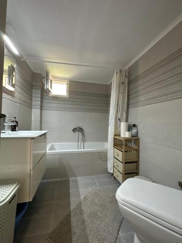 a bathroom with a tub and a toilet and a sink at Kiki's house Afytos in Afitos