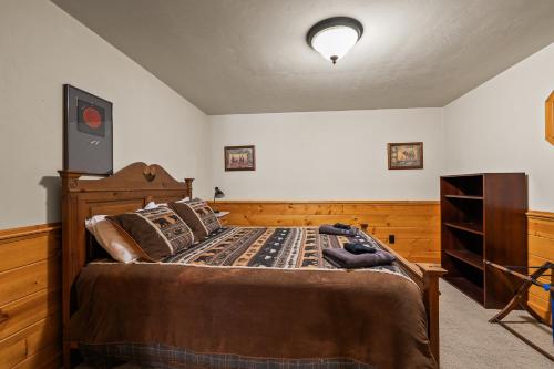 a bedroom with a bed with a wooden head board at Log Retreat at Fish Creek by Simple Life Rentals in Fish Creek