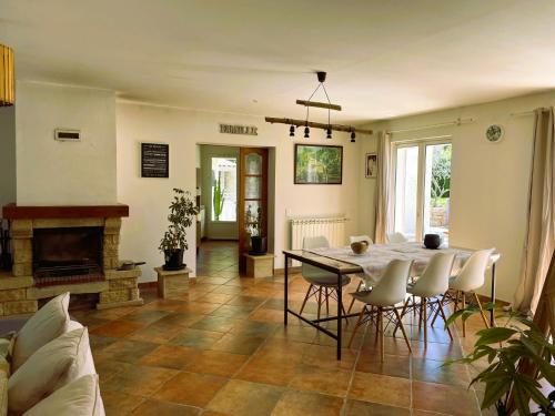 un salon avec une table et des chaises et une cheminée dans l'établissement Maison Shiva - Dracénie Experience, à Trans-en-Provence