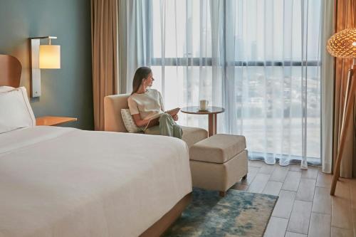 a woman sitting in a chair in a hotel room at Element Al Jaddaf, Dubai in Dubai