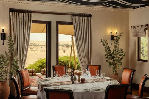 a dining room with a table and a large window at Al Maha, a Luxury Collection Desert Resort & Spa, Dubai in Murquab