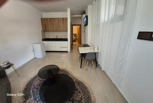 a living room with a table and a kitchen at Aley Pilot Residence in Al Qammāţīyah