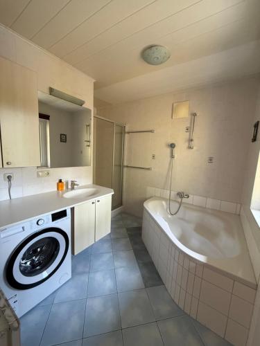 łazienka z wanną i pralką w obiekcie Appartement Berger w mieście Zell am See