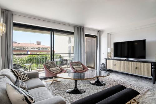 un salon avec un canapé et une télévision dans l'établissement -CLR- Charming 3-Bedroom Apartment in the Heart of Cannes, à Cannes