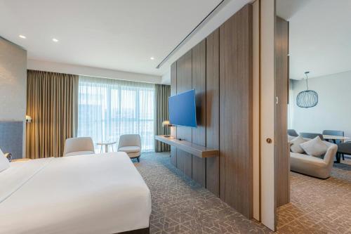 a hotel room with a bed and a flat screen tv at Courtyard by Marriott Dubai, Al Barsha in Dubai