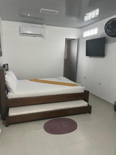 a bedroom with two beds and a flat screen tv at Casa Hotel La Mariela in Sapzurro
