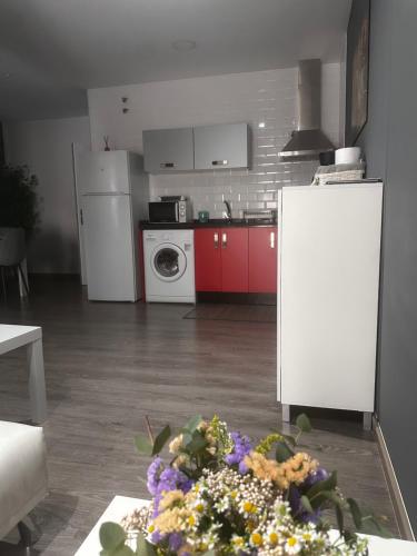 a kitchen with a table with flowers on the floor at Apartamentos Dacris in Jerte